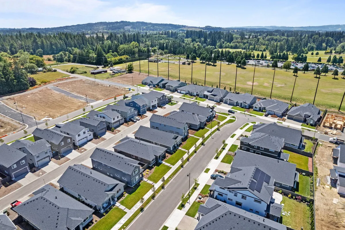 A view of residential houses with green spaces and roadways, providing a sense of the exterior circulation and available parking areas around the home.