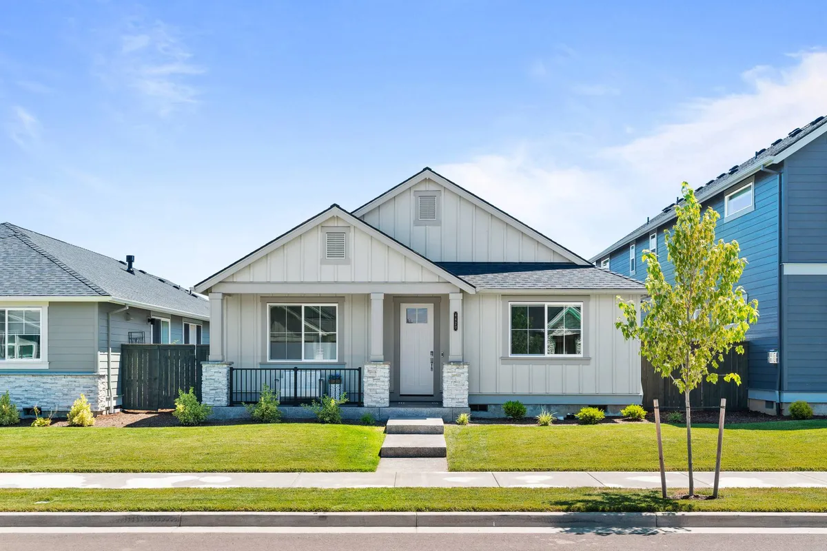 A welcoming view of the home's front porch and landscaped yard, with a symmetrical facade that invites families in. The scene evokes a sense of arrival, privacy, and the potential for outdoor gatherings or quiet moments on the porch.