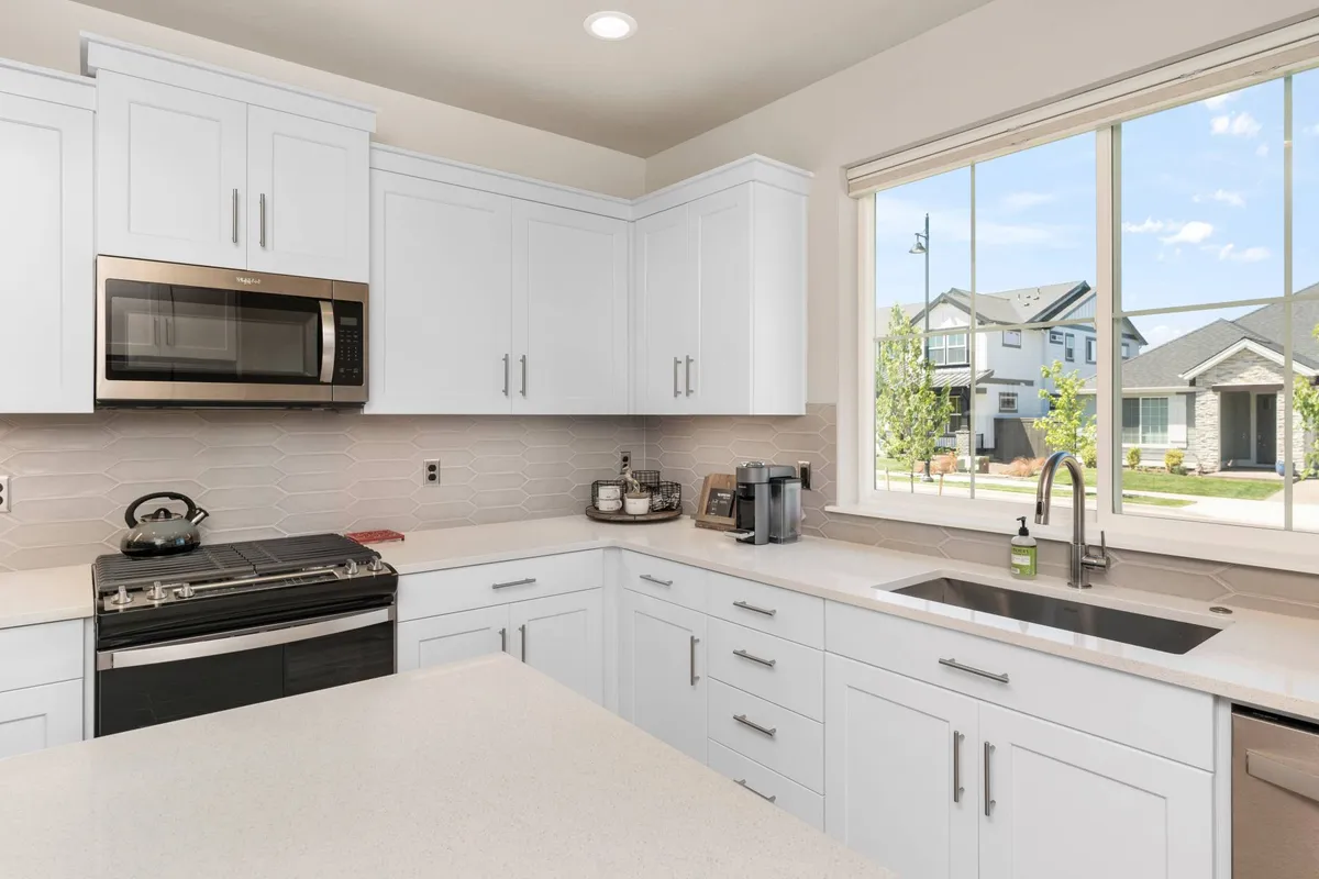A modern kitchen scene centered on a spacious island, gleaming stainless steel appliances, and a bright window view. The overall look is cheerful and functional, perfect for culinary adventures and socializing with family or guests.